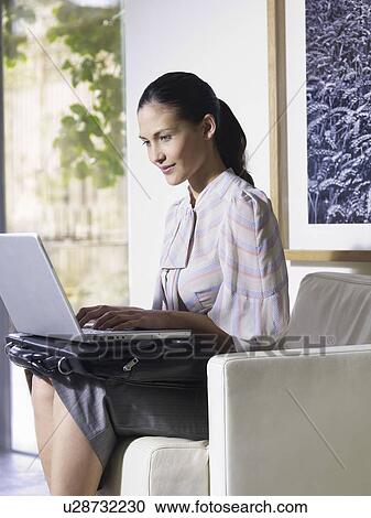 Woman using laptop in waiting room View Large Photo Image Stock Image - Woman using laptop in waiting room. Fotosearch