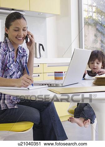 Woman working at home, son at table View Large Photo Image Stock Image - Woman working at home, son at table. Fotosearch