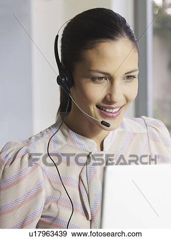 Stock Photo - Young woman wearing headset. Fotosearch