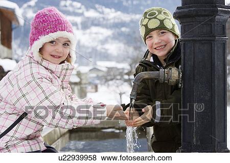 Boy and girl holding hands under tap View Large Photo Image Stock Photo - Boy and girl holding hands under tap. Fotosearch