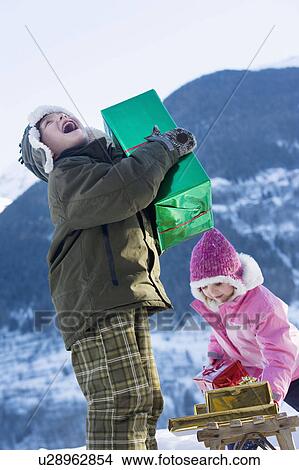Boy and girl with presents in the snow View Large Photo Image Picture - Boy and girl with presents in the snow. Fotosearch