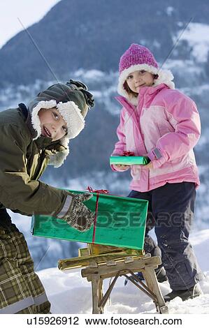 Boy and girl with presents in the snow View Large Photo Image Stock Image - Boy and girl with presents in the snow. Fotosearch