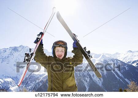 Boy holding skis above his head View Large Photo Image Picture - Boy holding skis above his head. Fotosearch