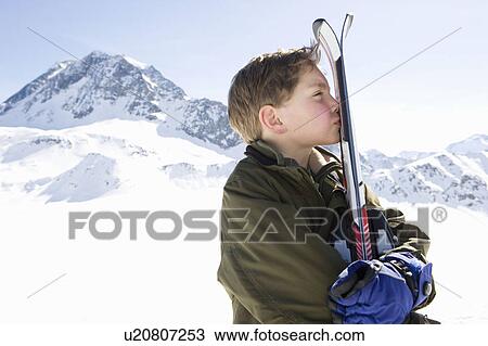 Stock Image - Boy holding skis. Fotosearch