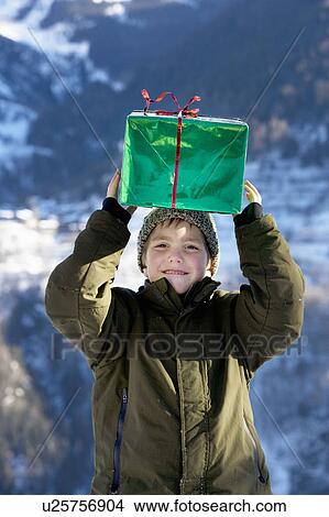Picture - Boy with present in the snow. Fotosearch