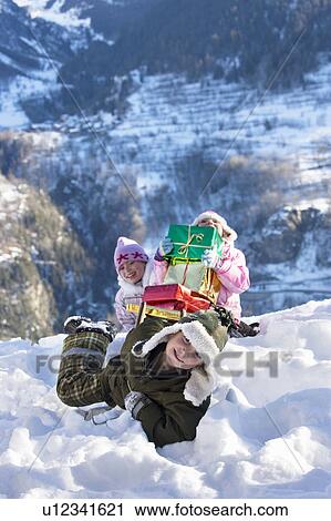 Children playing in snow with presents View Large Photo Image Stock Image - Children playing in snow with presents. Fotosearch