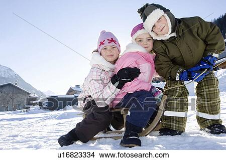 Children playing in snow with sledge View Large Photo Image Picture - Children playing in snow with sledge. Fotosearch