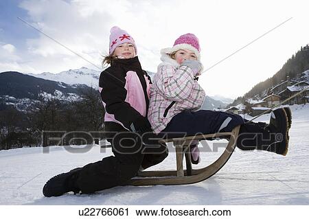 Girls towed on sledge in snow View Large Photo Image Stock Image - Girls towed on sledge in snow. Fotosearch