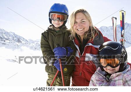 Stock Image - Mother, son, and daughter with skis. Fotosearch