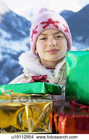 Picture - Portrait of girl with presents in snow. Fotosearch