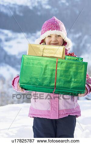 Stock Photo - Portrait of girl with presents in snow. Fotosearch