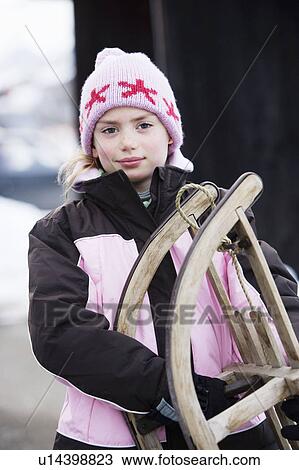Stock Image - Portrait of young girl with sledge. Fotosearch