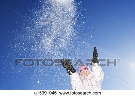 Stock Photograph - Young girl throwing snow in the air. Fotosearch