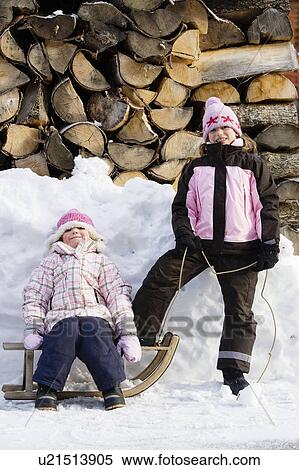 Young girls posing with sledge on snow View Large Photo Image Stock Photography - Young girls posing with sledge on snow. Fotosearch