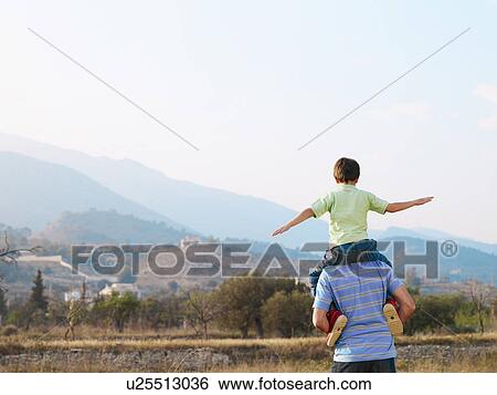 Father carrying son (6-8) on shoulders in field, rear view View Large Photo Image Stock Photograph - Father carrying son (6-8) on shoulders in field, rear view. Fotosearch