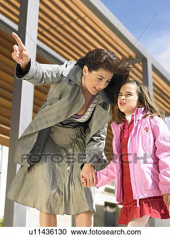 Low angle view of mother pointing at something to show daughter (5-7), wind blowing their hair, Alicante, Spain, View Large Photo Image Stock Image - Low angle view of mother pointing at something to show daughter (5-7), wind blowing their hair, Alicante, Spain,. Fotosearch