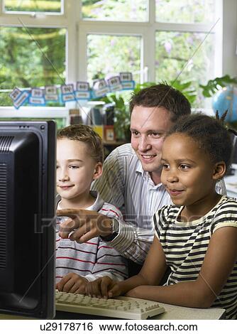 Male teacher looking at computer monitor with boy and girl View Large Photo Image Stock Photograph - Male teacher looking at computer monitor with boy and girl. Fotosearch