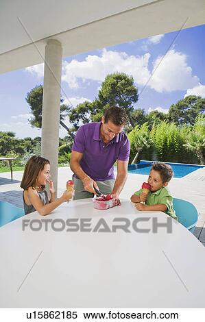 Stock Photography - Man serving ice cream to boy and girl.. Fotosearch