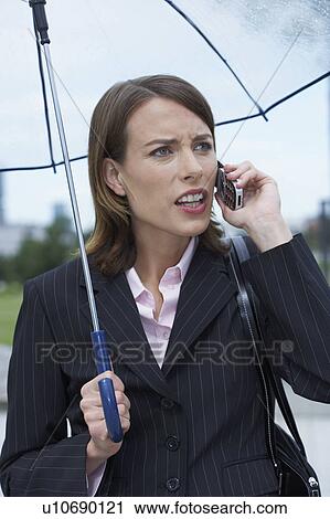 Angry businesswoman under umbrella on cell phone. View Large Photo Image Stock Image - Angry businesswoman under umbrella on cell phone.. Fotosearch