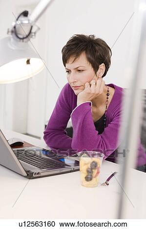 Bored woman sitting in front of her pc View Large Photo Image Stock Image - Bored woman sitting in front of her pc. Fotosearch