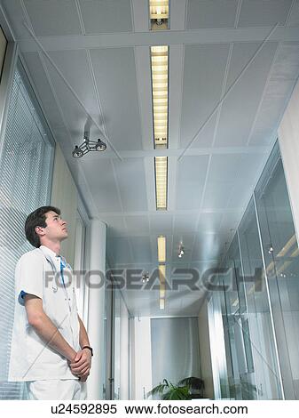 Concerned young doctor in a lobby of a hospital. Low angle. View Large Photo Image Stock Photography - Concerned young doctor in a lobby of a hospital. Low angle.. Fotosearch