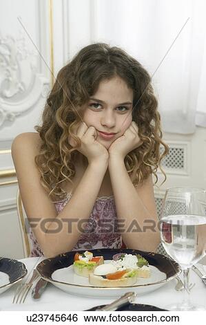 Girl (9-11) leaning on dinner table, portrait View Large Photo Image Stock Photograph - Girl (9-11) leaning on dinner table, portrait. Fotosearch