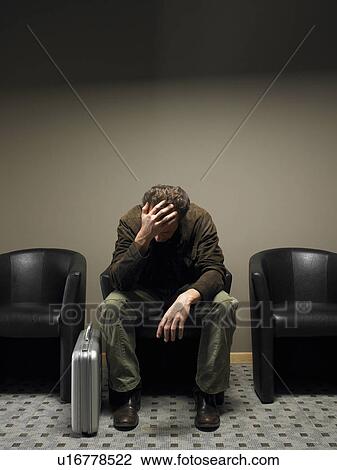 Mature businessman sitting with head bowed in waiting room View Large Photo Image Stock Image - Mature businessman sitting with head bowed in waiting room. Fotosearch