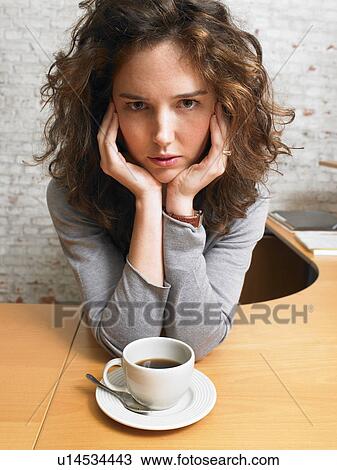 Serious woman looking at camera at desk with coffee cup., Brussels, Belgium. View Large Photo Image Stock Image - Serious woman looking at camera at desk with coffee cup., Brussels, Belgium.. Fotosearch