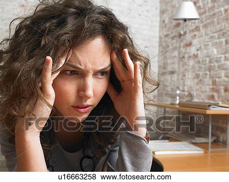 Stock Photo - Stressed woman at desk., Brussels, Belgium.. Fotosearch