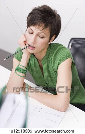 Woman chewing a pencil View Large Photo Image Stock Photography - Woman chewing a pencil. Fotosearch