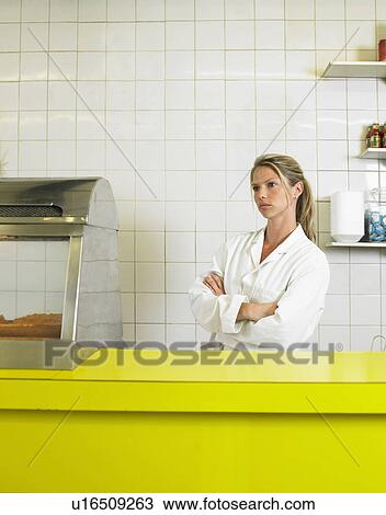 Young woman behind counter in fish and chip shop, arms folded View Large Photo Image Stock Image - Young woman behind counter in fish and chip shop, arms folded. Fotosearch