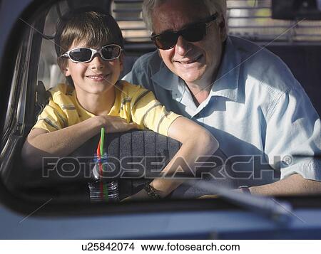 Boy (8-10) and grandfather in sunglasses sitting in backseat of car, portrait View Large Photo Image Picture - Boy (8-10) and grandfather in sunglasses sitting in backseat of car, portrait. Fotosearch