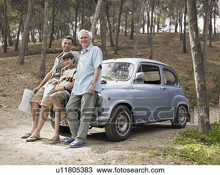 Boy (8-10) leaning on car bonnet with father and grandfather, man holding map View Large Photo Image Stock Image - Boy (8-10) leaning on car bonnet with father and grandfather, man holding map. Fotosearch