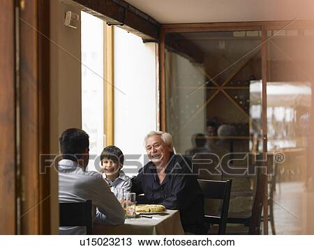 Boy (8-10) sitting at café table with father and grandfather, smiling, portrait View Large Photo Image Stock Image - Boy (8-10) sitting at café table with father and grandfather, smiling, portrait. Fotosearch