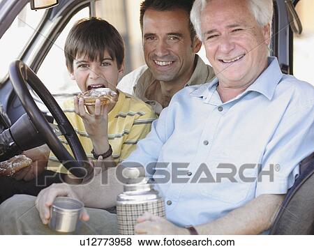 Boy (8-10) sitting in car with father and grandfather, eating doughnut, portrait View Large Photo Image Stock Photo - Boy (8-10) sitting in car with father and grandfather, eating doughnut, portrait. Fotosearch