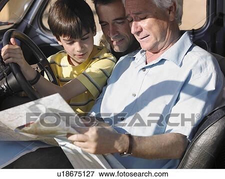 Boy (8-10) sitting in car with father and grandfather, looking at road map View Large Photo Image Stock Photo - Boy (8-10) sitting in car with father and grandfather, looking at road map. Fotosearch