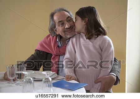 Girl (6-8) kissing grandfather at dinner table View Large Photo Image Stock Image - Girl (6-8) kissing grandfather at dinner table. Fotosearch