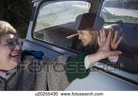 Grandmother and granddaughter (10-12) holding hands on car window View Large Photo Image Stock Image - Grandmother and granddaughter (10-12) holding hands on car window. Fotosearch