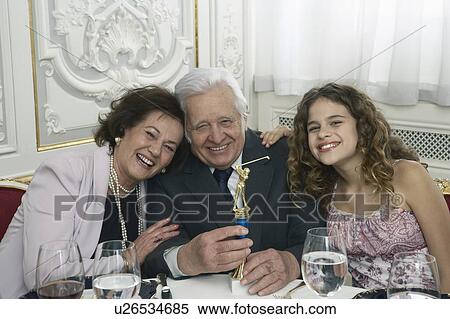 Senior couple and granddaughter (9-11) holding golf trophy View Large Photo Image Stock Photography - Senior couple and granddaughter (9-11) holding golf trophy. Fotosearch