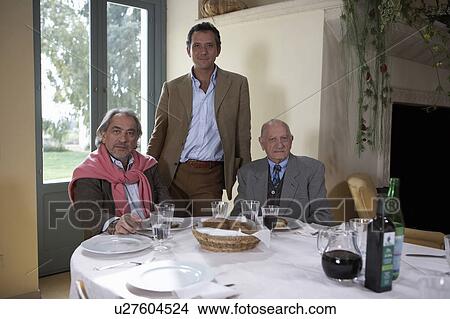 Picture - Three generation family at table, portrait. Fotosearch