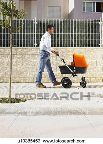 Father pushing pram on pavement, Alicante, Spain, View Large Photo Image Stock Image - Father pushing pram on pavement, Alicante, Spain,. Fotosearch