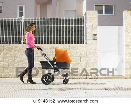 Mother pushing pram on pavement, Alicante, Spain, View Large Photo Image Stock Image - Mother pushing pram on pavement, Alicante, Spain,. Fotosearch