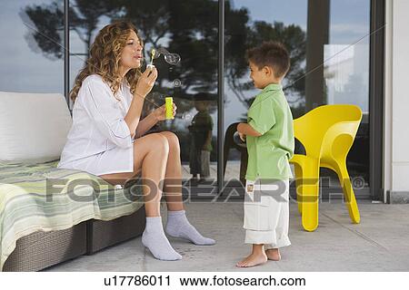 Woman and boy blowing bubbles. View Large Photo Image Stock Image - Woman and boy blowing bubbles.. Fotosearch