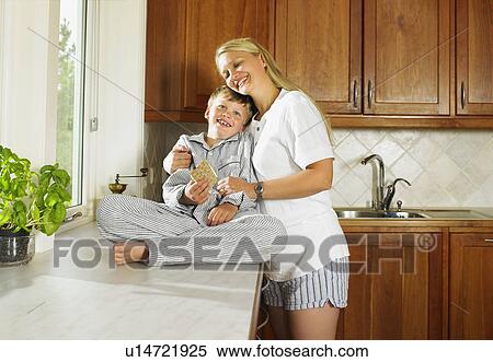 Stock Photography - Woman and young boy holding sandwich in kitchen.. Fotosearch