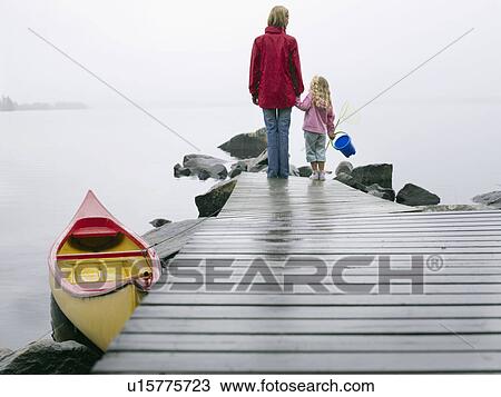 Woman and young girl holding a pail on a dock near a boat. View Large Photo Image Stock Image - Woman and young girl holding a pail on a dock near a boat.. Fotosearch