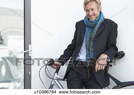 Picture - Businessman wearing extravagant scarf with bicycle.. Fotosearch