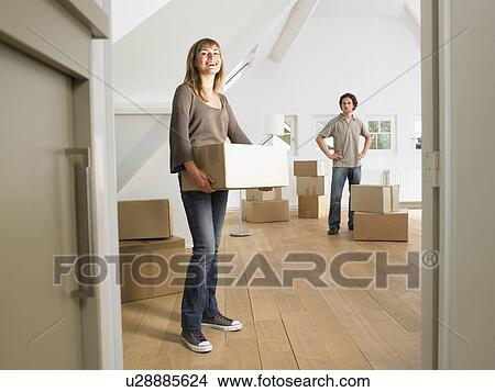 Couple moving into new home smiling. View Large Photo Image Picture - Couple moving into new home smiling.. Fotosearch