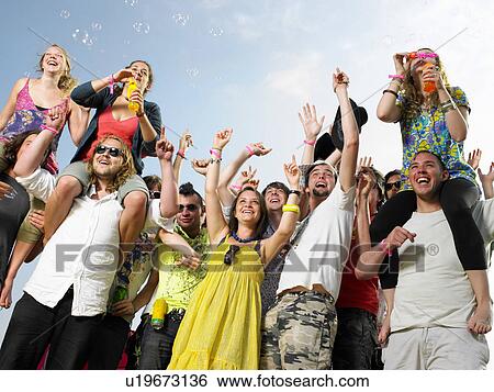 Stock Photograph - Crowd of young people cheering and waving. Fotosearch