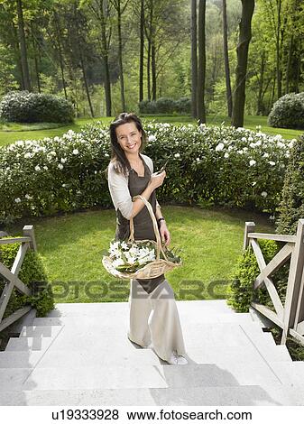 Stock Photo - Woman gardening outdoors smiling.. Fotosearch