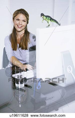 Woman in Office at computer desk smiling. View Large Photo Image Stock Photo - Woman in Office at computer desk smiling.. Fotosearch